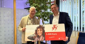 Marius Möller (rechts) von der Sparkasse Südholstein übergibt den 5.000-Euro-Gewinn an Hermann Reumann. Foto: Sparkasse Südholstein